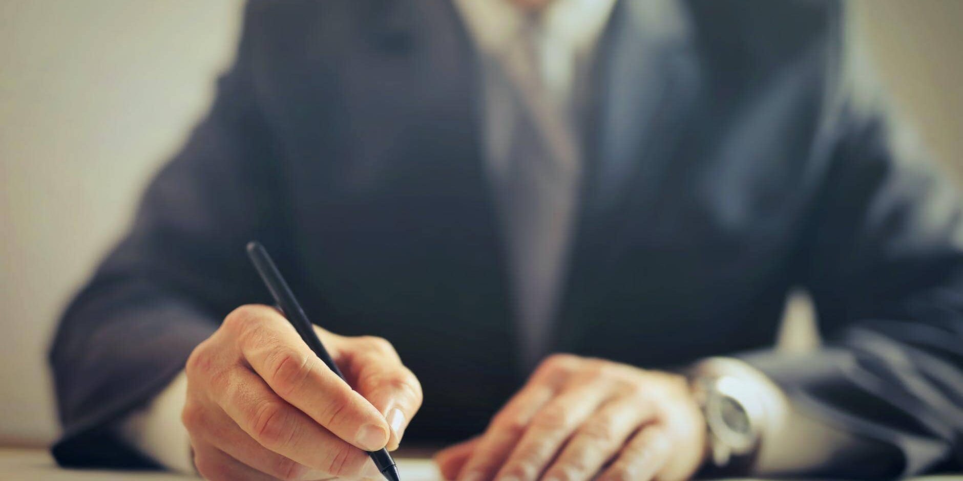 crop businessman signing contract in office